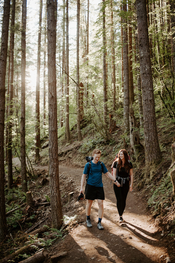 couple walking in the forest, and long trees are around them