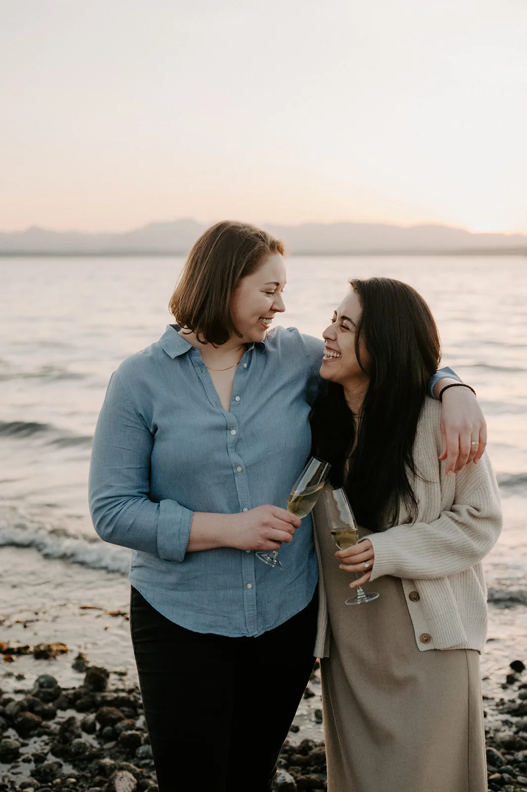 a couple celebrates with champage during their engagement session at carkeek park