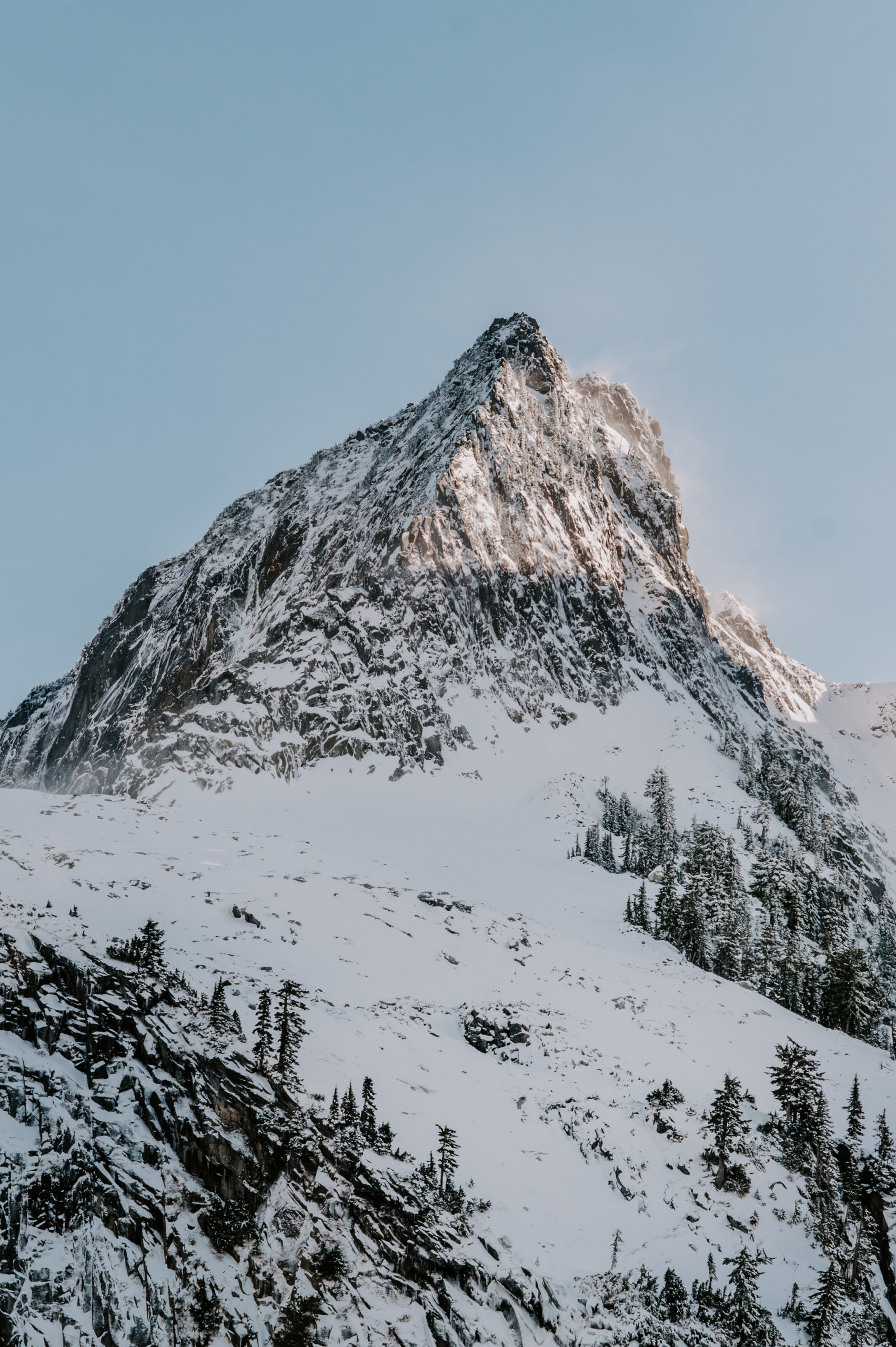 A striking snow-covered mountain peak rising against a clear blue sky in the Cascade Range.
