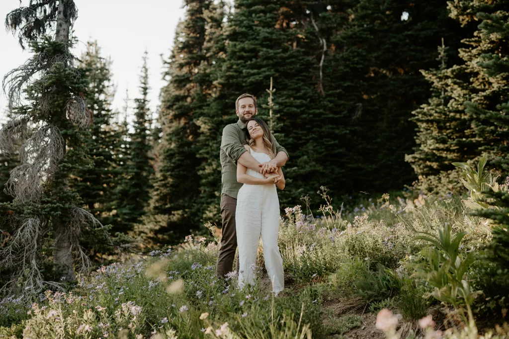 romantic engagement couple posing at a green hill area