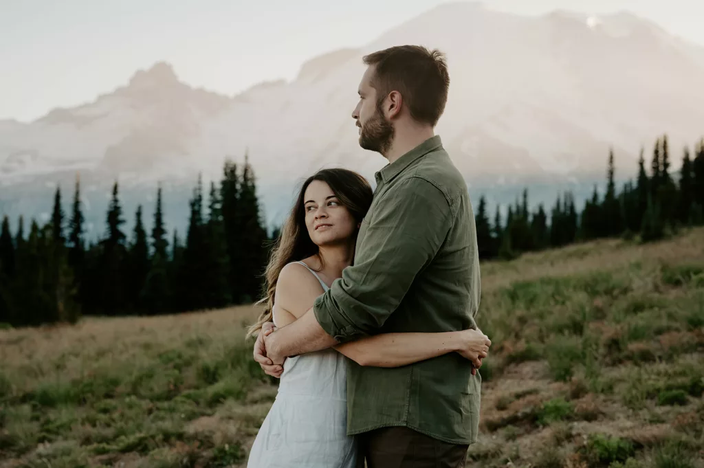 engagement couple at a green hill calmly hugging