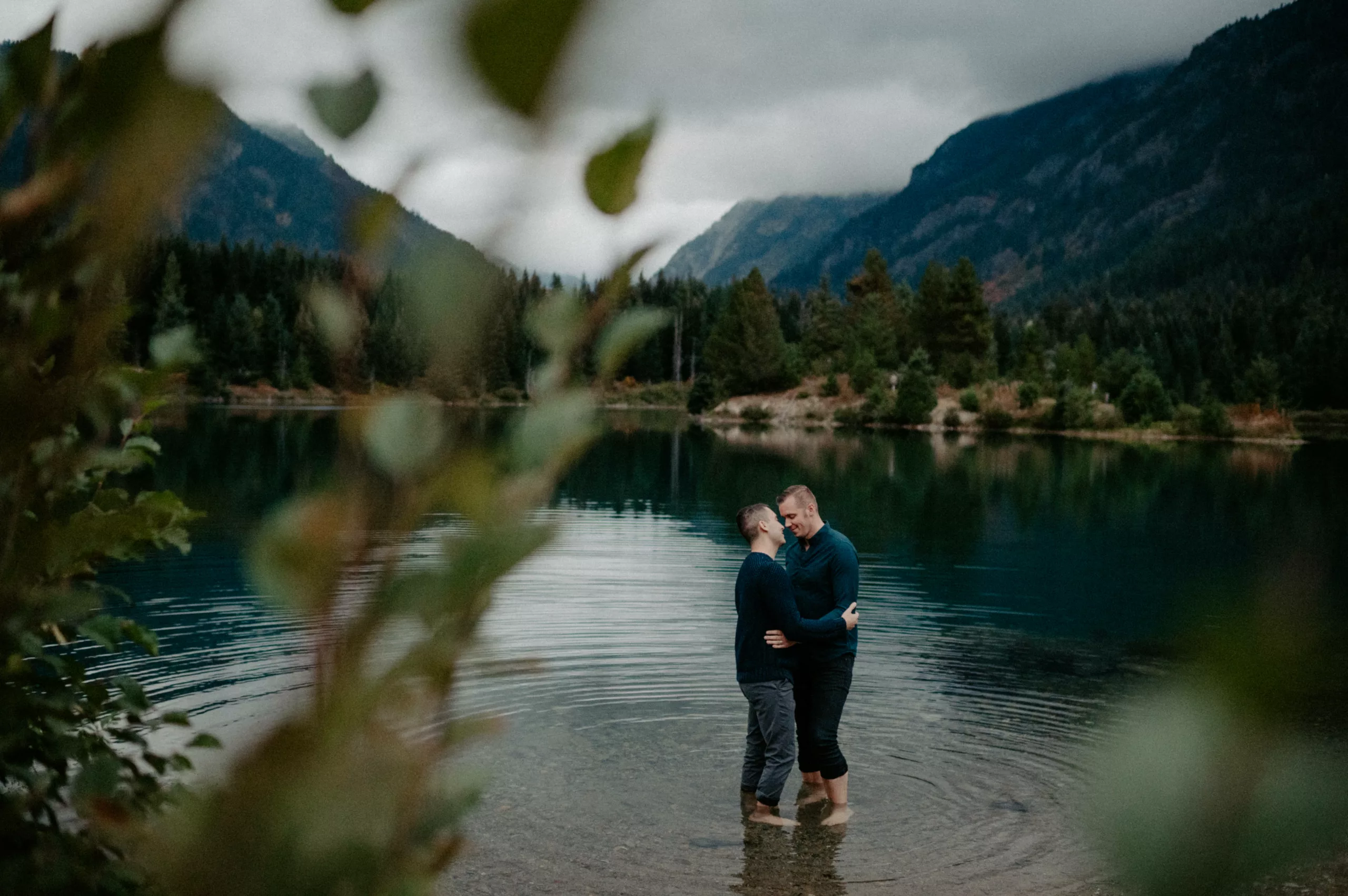 a gay couple embraces while standing in shallow water at gold creek pond