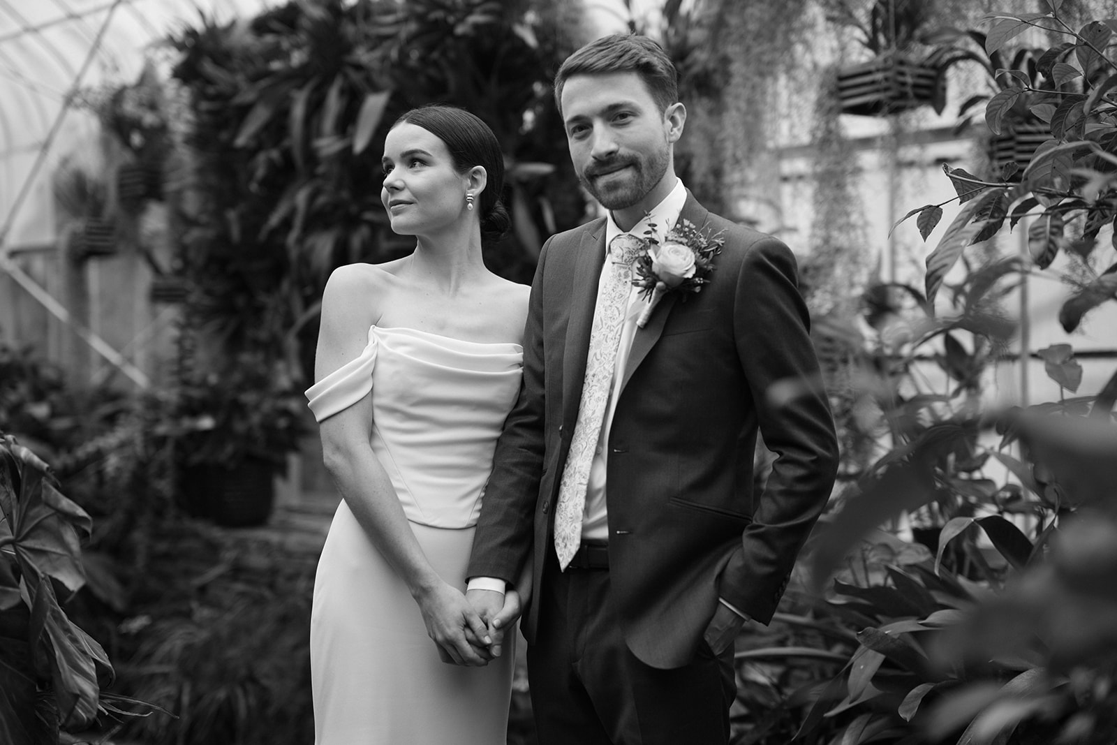A timeless black-and-white photo of Taylor and Patrick holding hands in the Seymour Conservatory.