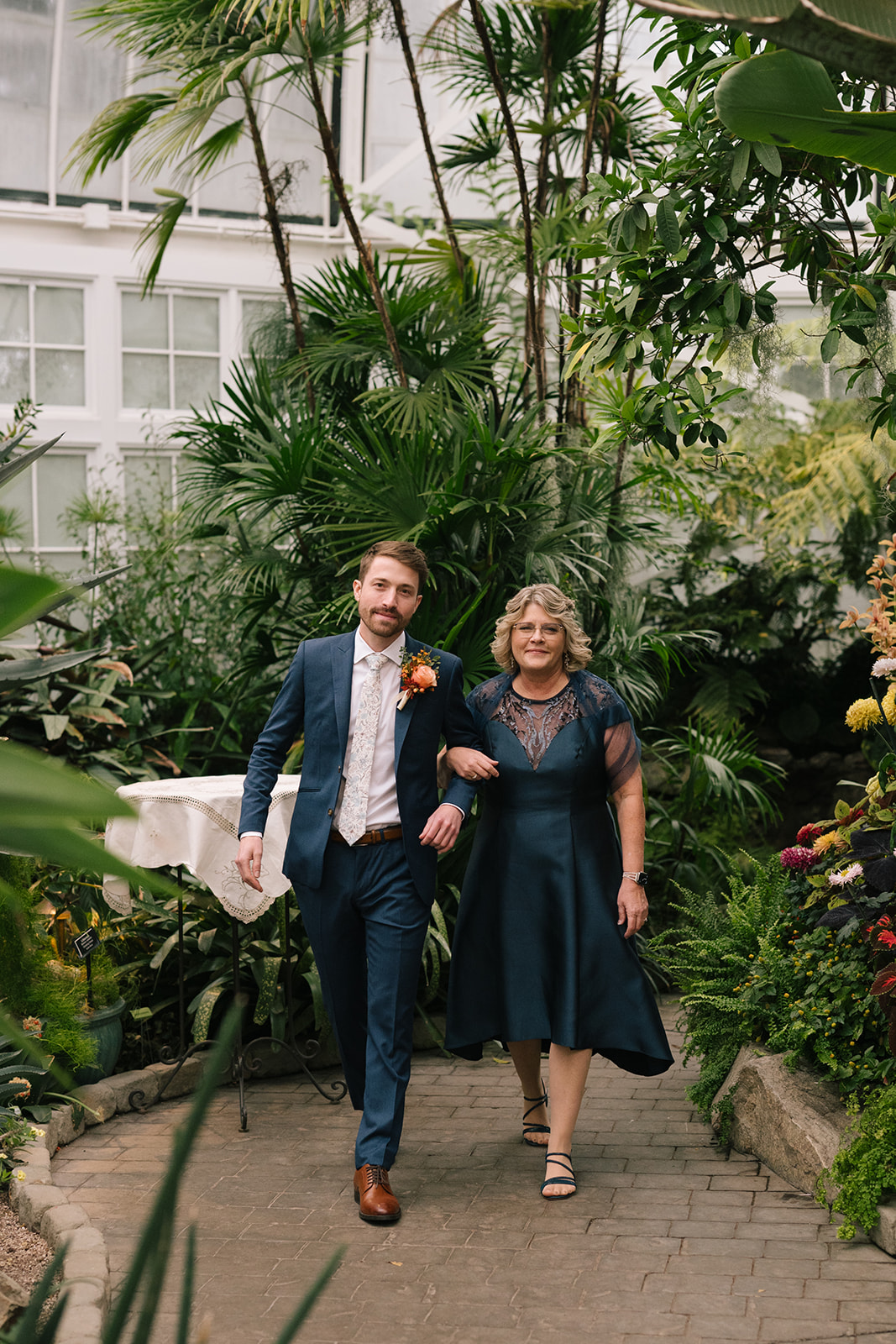 Patrick and his mother walking side by side through the Seymour Conservatory's greenery.