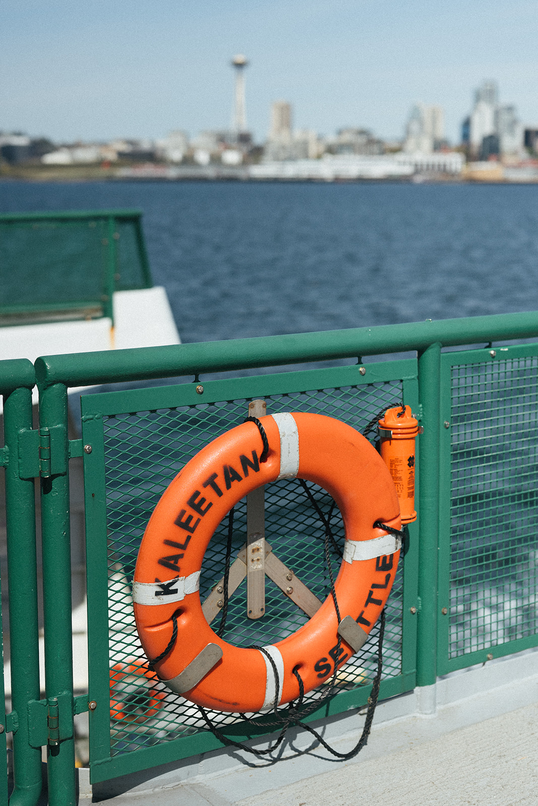 Bright orange Kaleetan life ring on the ferry with the Space Needle in the background