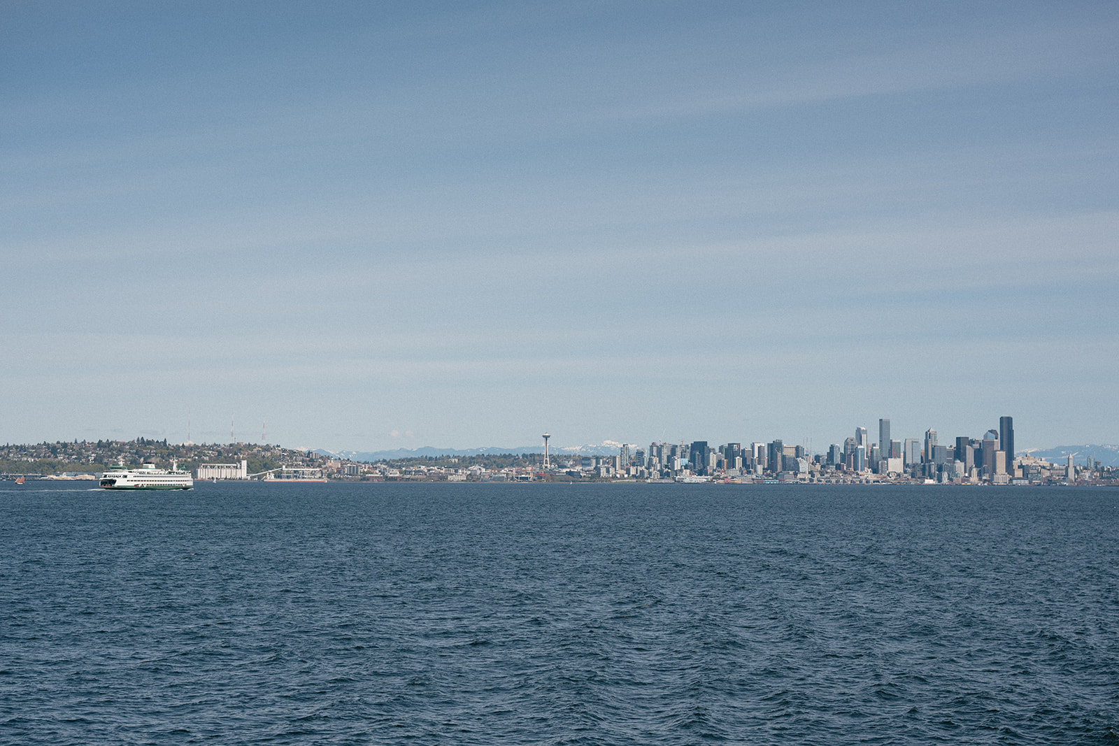 Distant view of a Seattle-bound ferry crossing Elliott Bay on a clear day