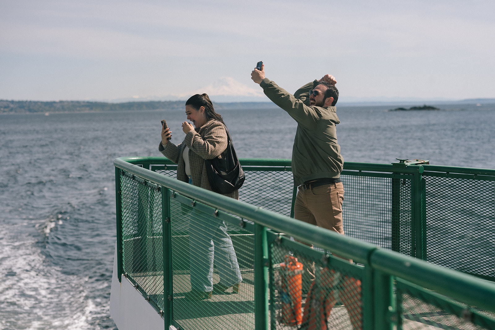 Johnny pumps his fist in joy next to Alyssa on the ferry bow