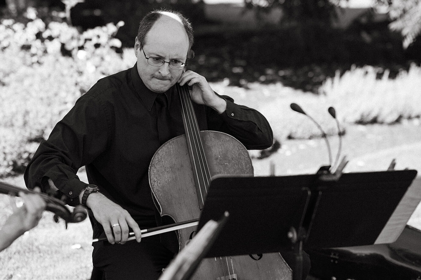 Cellist playing outdoors during ceremony at garden wedding