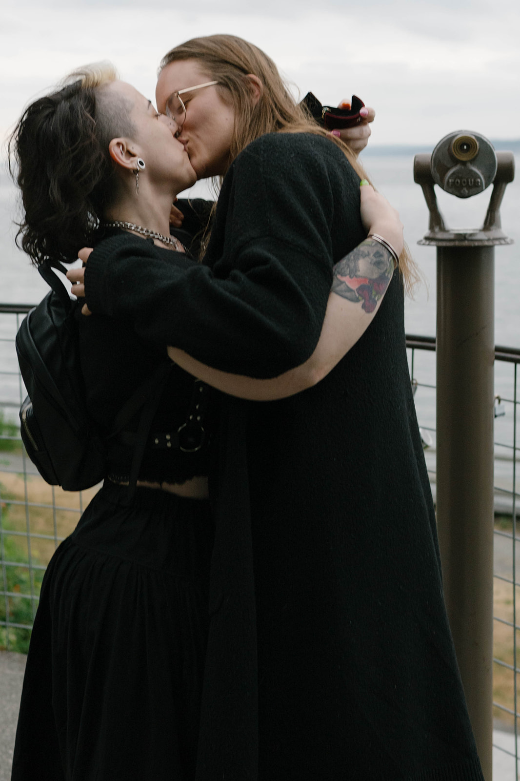 Two women kissing at a Whidbey Island whale watching overlook moments after a surprise proposal.