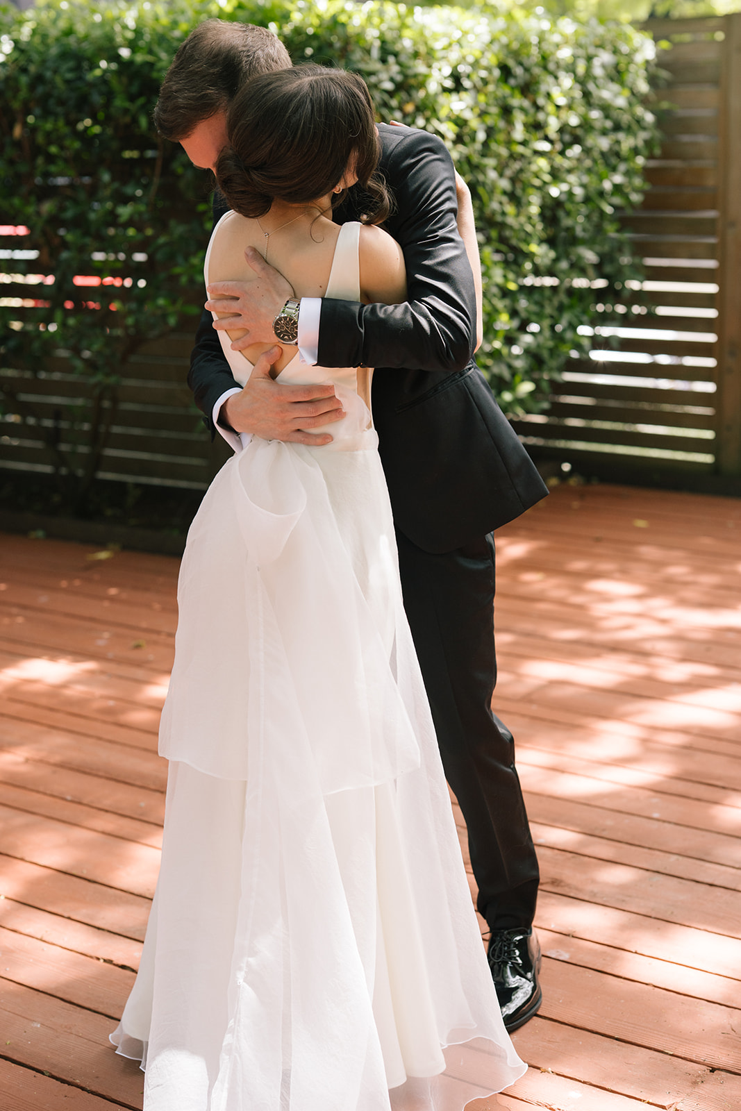 Bride and groom embrace during their first look on the Fremont Foundry rooftop deck in Seattle