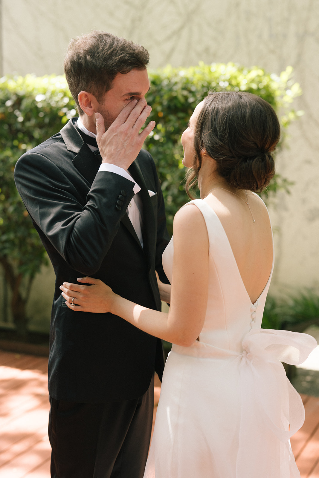Groom wipes away tears during first look with bride at the Fremont Foundry rooftop in Seattle