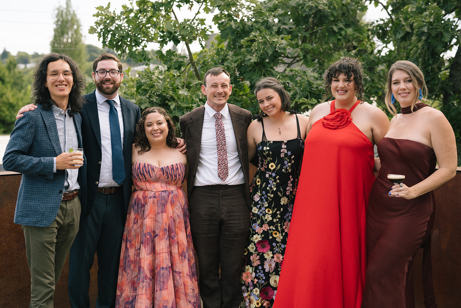 Group of wedding guests posing together on the Fremont Foundry rooftop during cocktail hour in Seattle