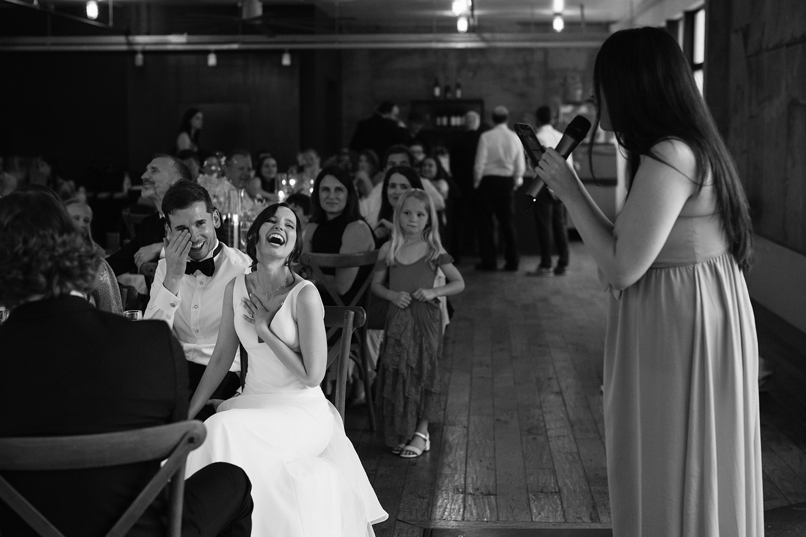 Bride and groom laughing during a speech at their Fremont Foundry wedding reception