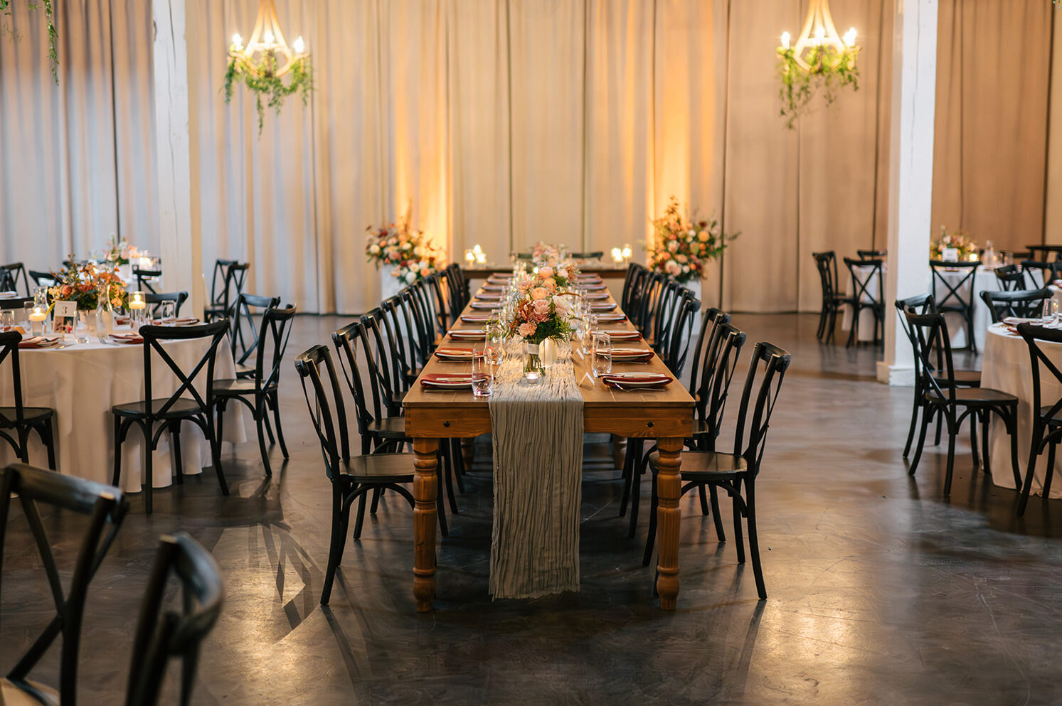 Romantic reception tables with candles and lush florals at Hideaway Cellars
