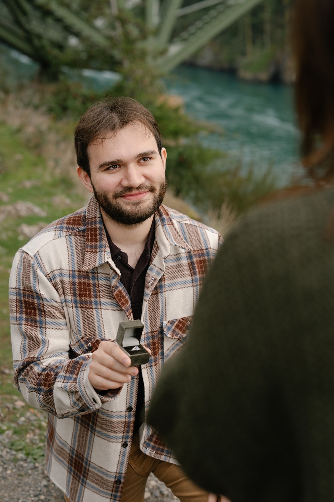Jonathan holds out the engagement ring to Ashley as he proposes.