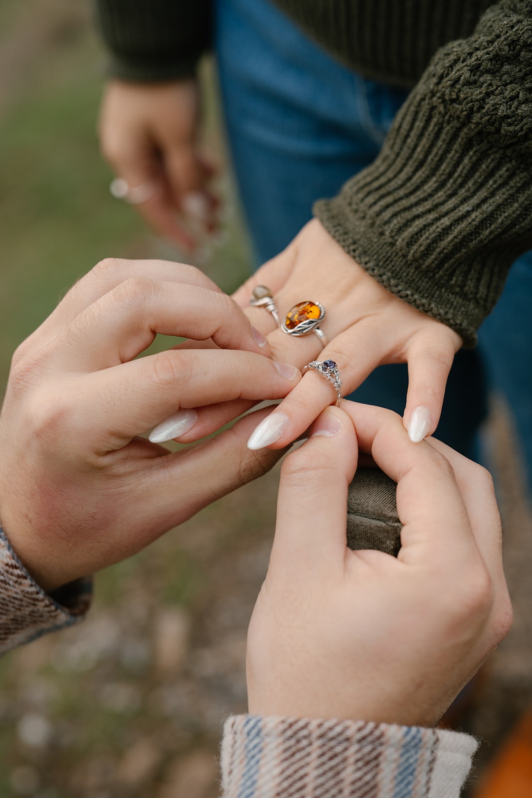 Jonathan gently slides the engagement ring onto Ashley’s finger.