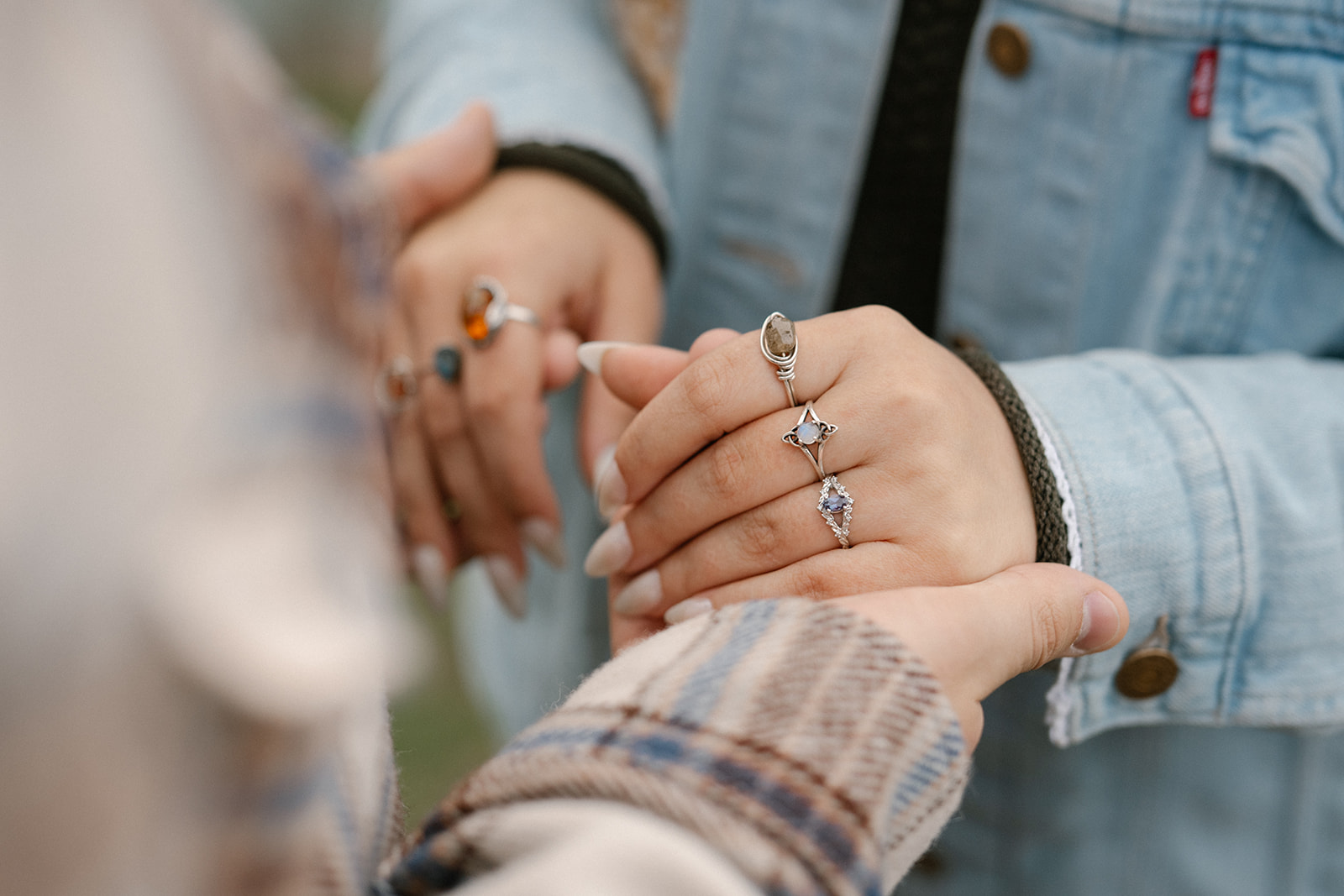 Close-up of Jonathan holding Ashley’s hand, showing her engagement ring during their Deception Pass proposal.