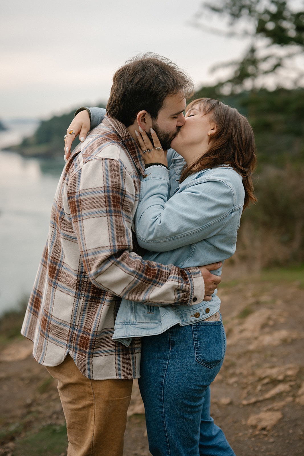 Jonathan and Ashley share a kiss on the cliffside after getting engaged at Deception Pass.