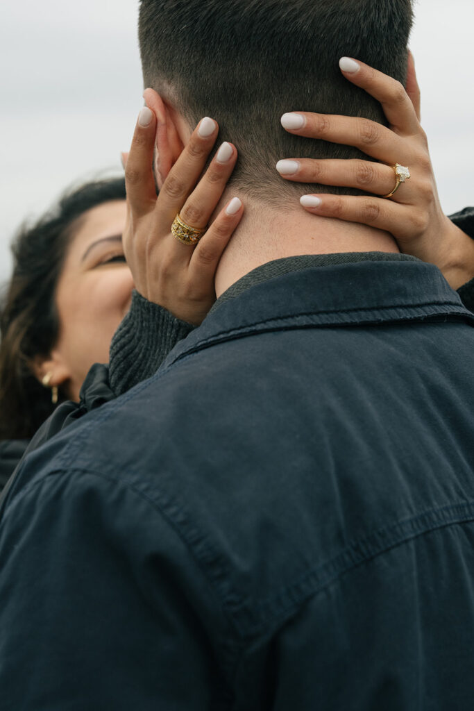 Aysha cups Brad’s face and kisses him, her new engagement ring visible on her hand.