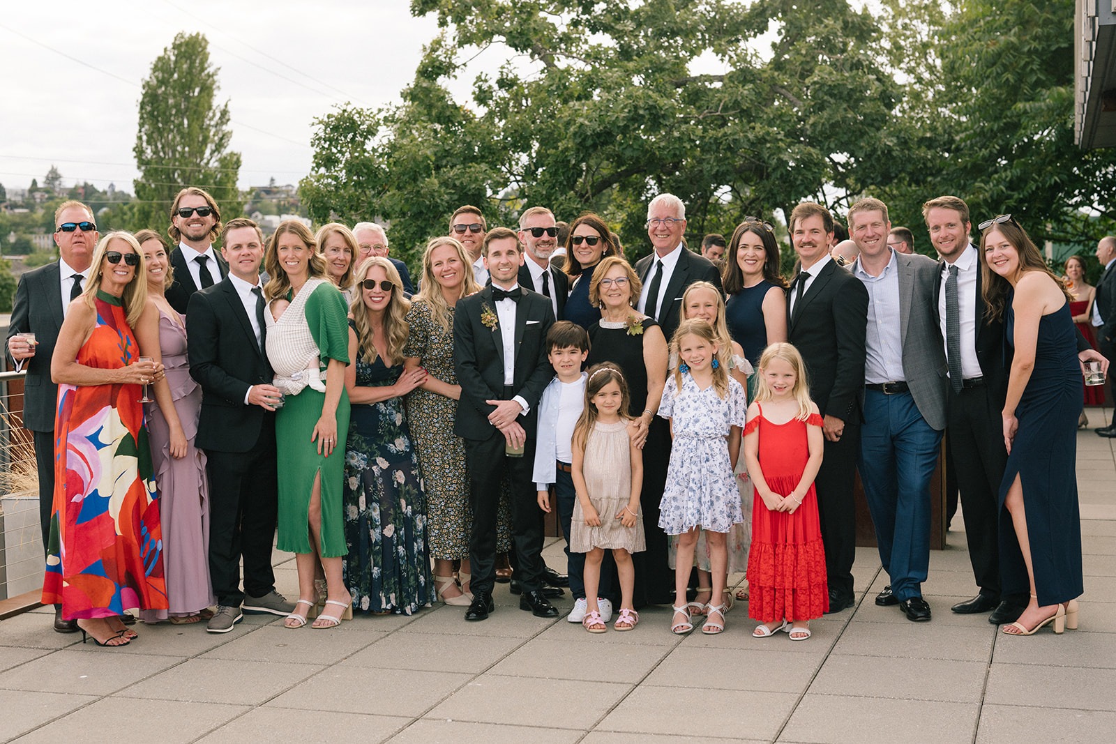 Large group of wedding guests posing together on the Fremont Foundry rooftop in Seattle