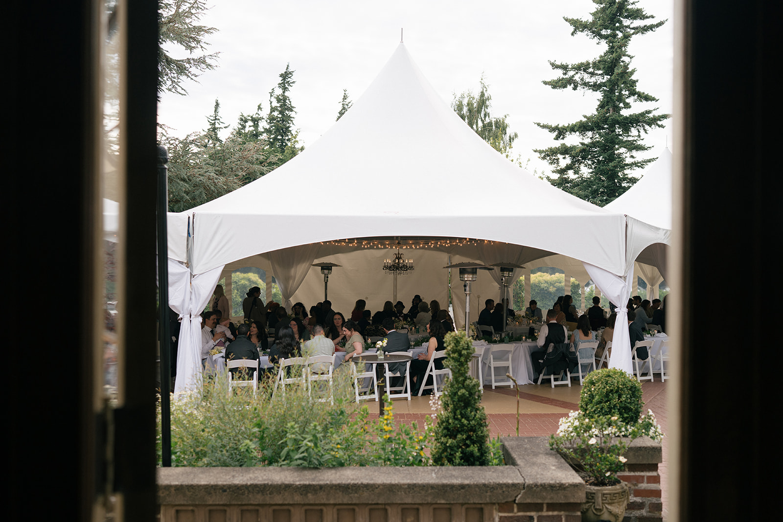 Large white reception tent filled with guests during dinner