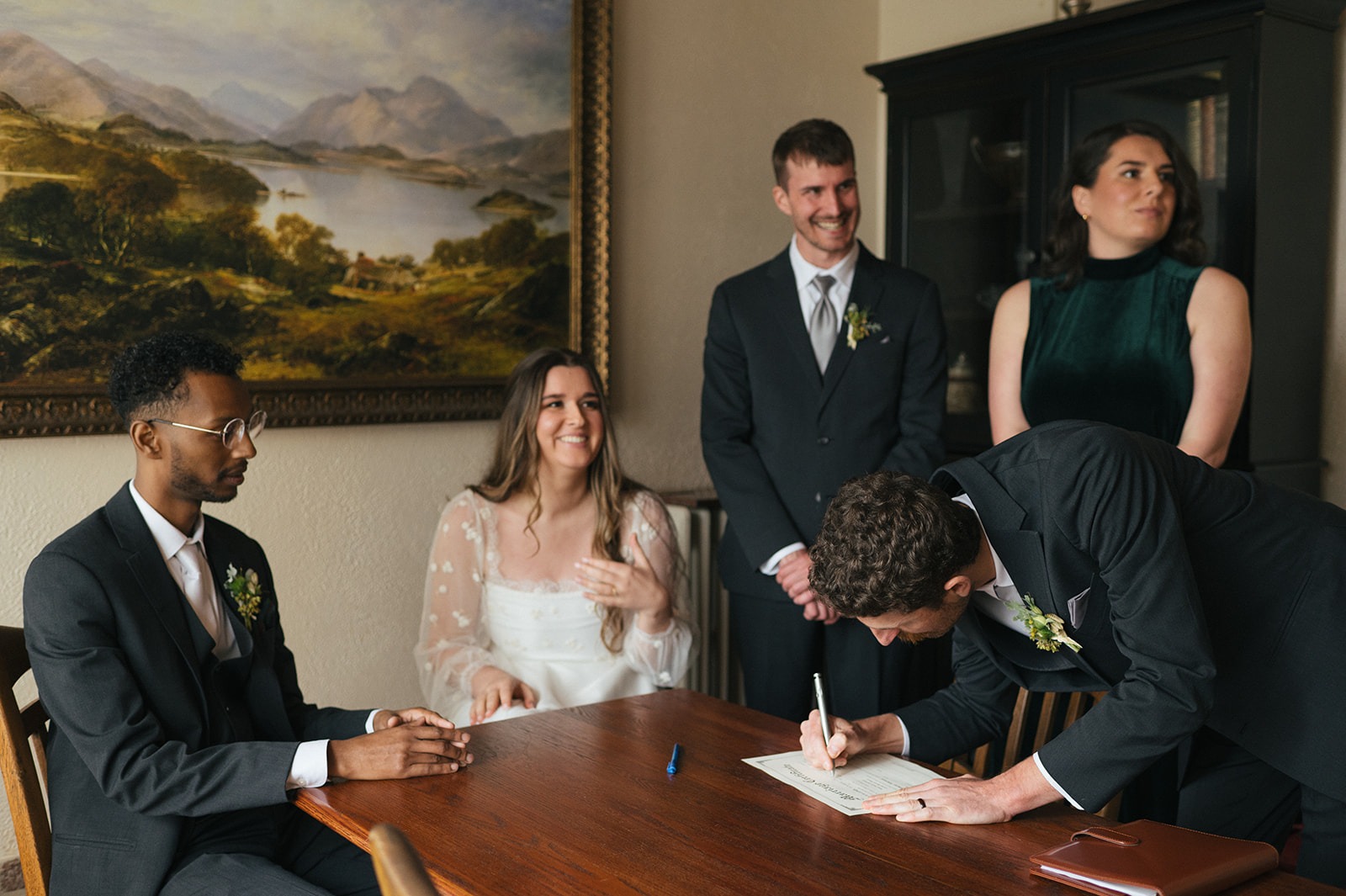Wedding witnesses signing the marriage license beside the couple at Lairmont Manor