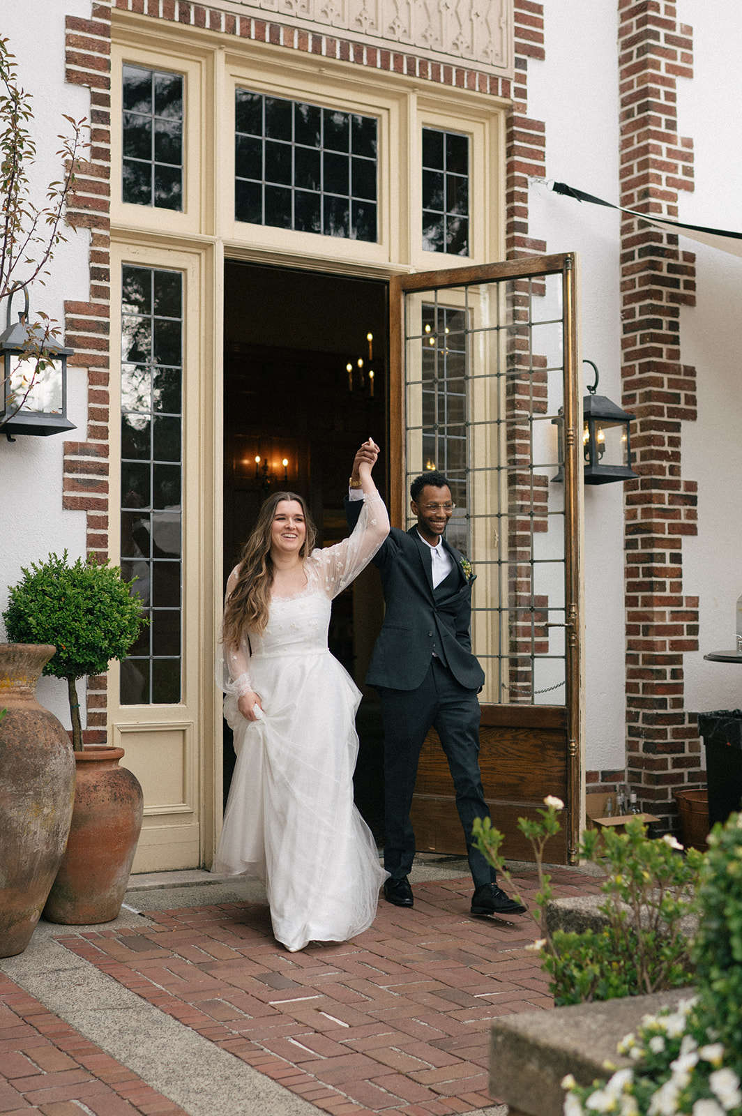 Bride and groom entering their reception through open doors at Lairmont Manor wedding