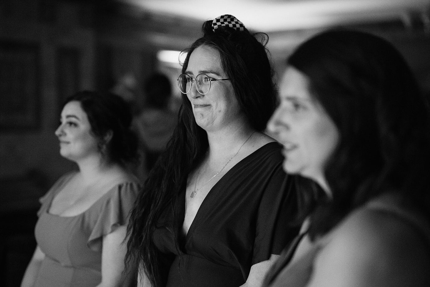 Bridesmaids reacting emotionally while watching the bride during wedding preparations